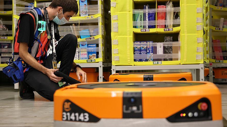 Un empleado controla robots en la zona de almacenaje del almacén de Amazon en El Prat.