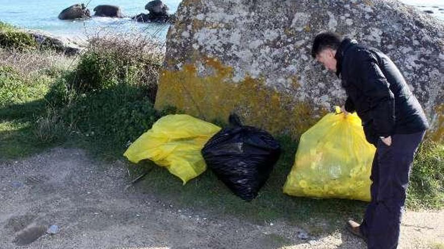 El concejal muestra basura recogida de A Lanzada.  //  Muñiz