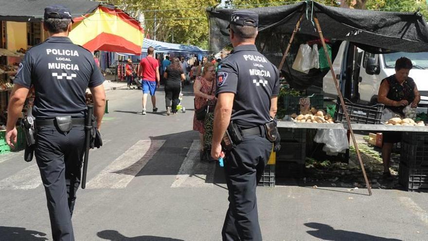 Dos agentes de la Policía Local de Murcia vigilan el mercado semanal de la avenida de La Fama.