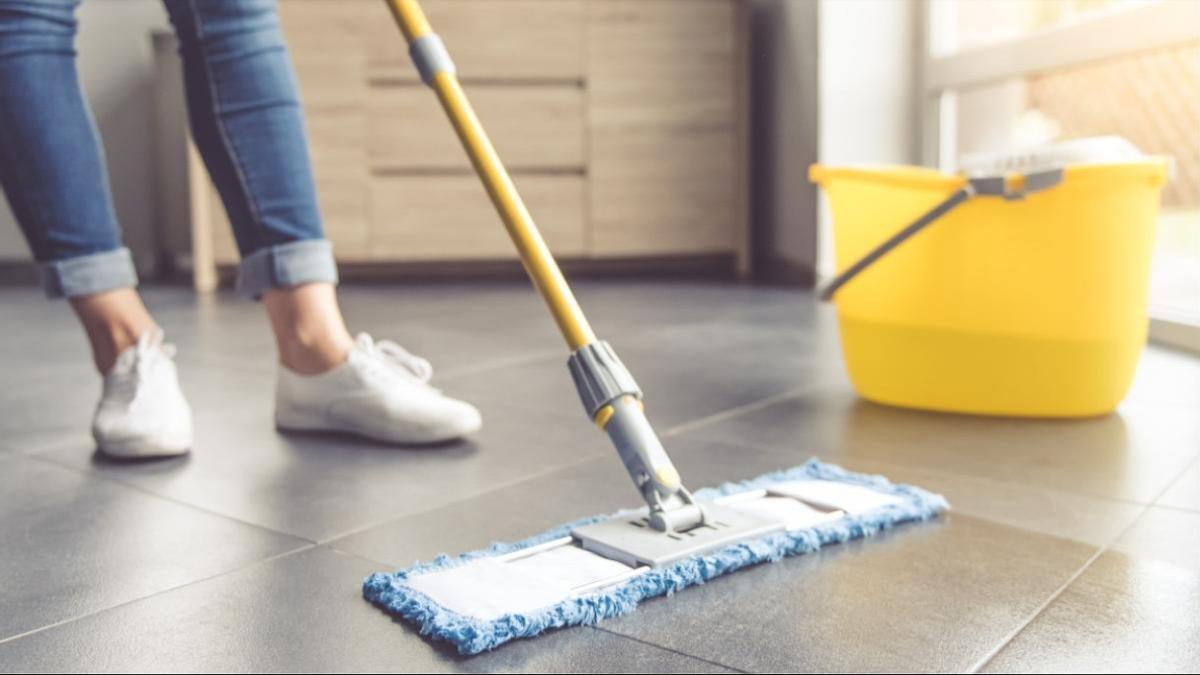 Detergente de limpieza y trapeador en el piso de una sala de estar