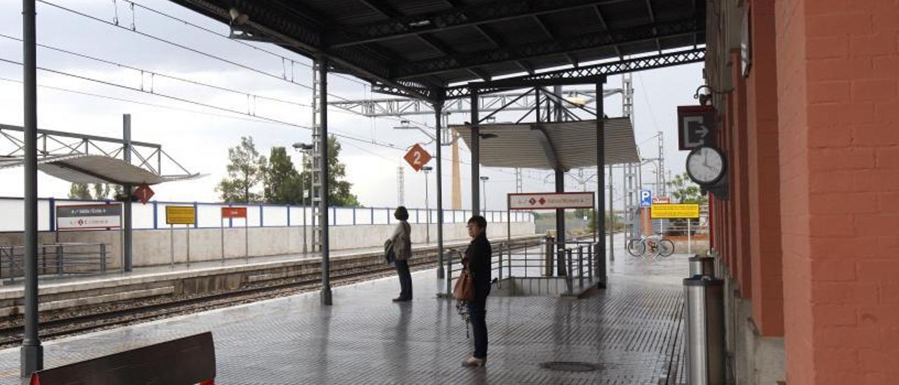 Dos viajeras aguardan la llegada del convoy en la estación de Renfe de Carcaixent. | V. M. PASTOR