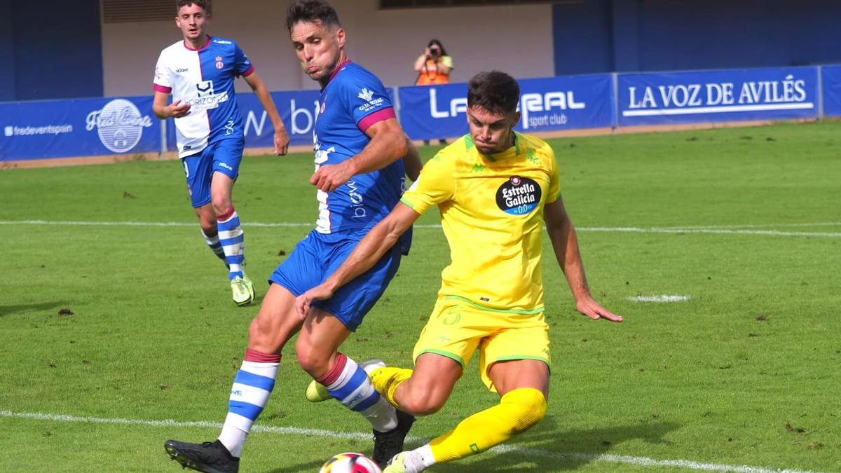 Puerto intenta despejar el balón ante un jugador del Avilés.