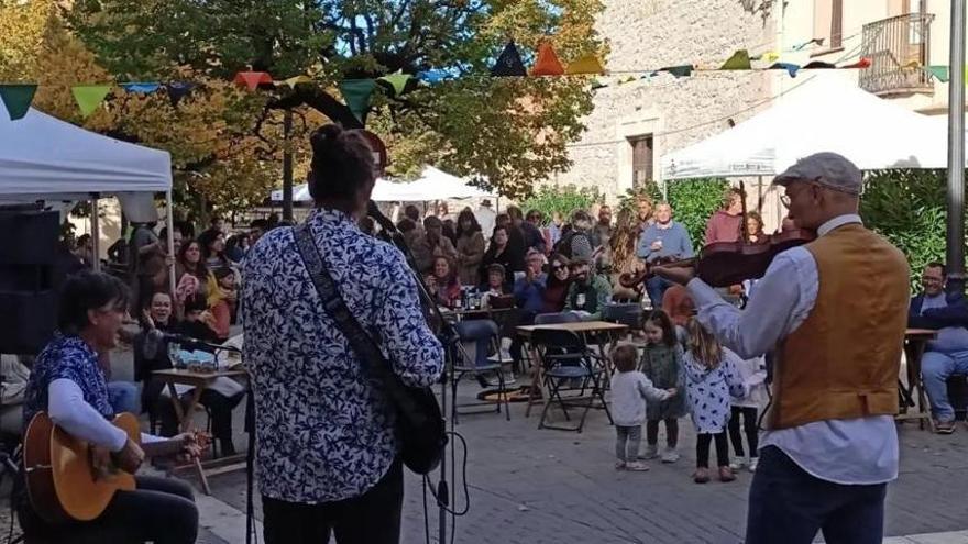 Els musics en primer terme i la mostra de productes de Carme al fons