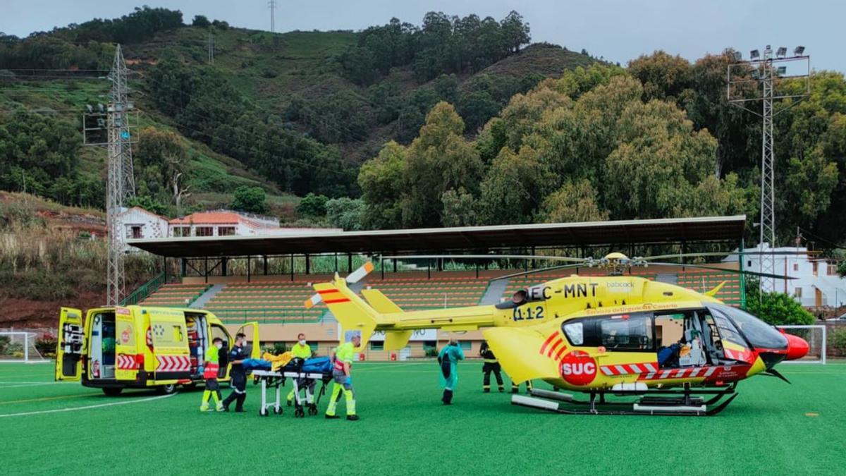 Los sanitarios durante el traslado de la niña de la ambulancia al helicóptero en el campo de fútbol de Teror. | | E.D.