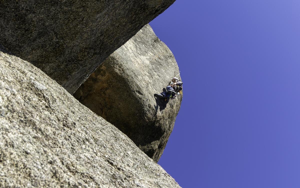 En joven escalando un saliente de granito en Torrelodones