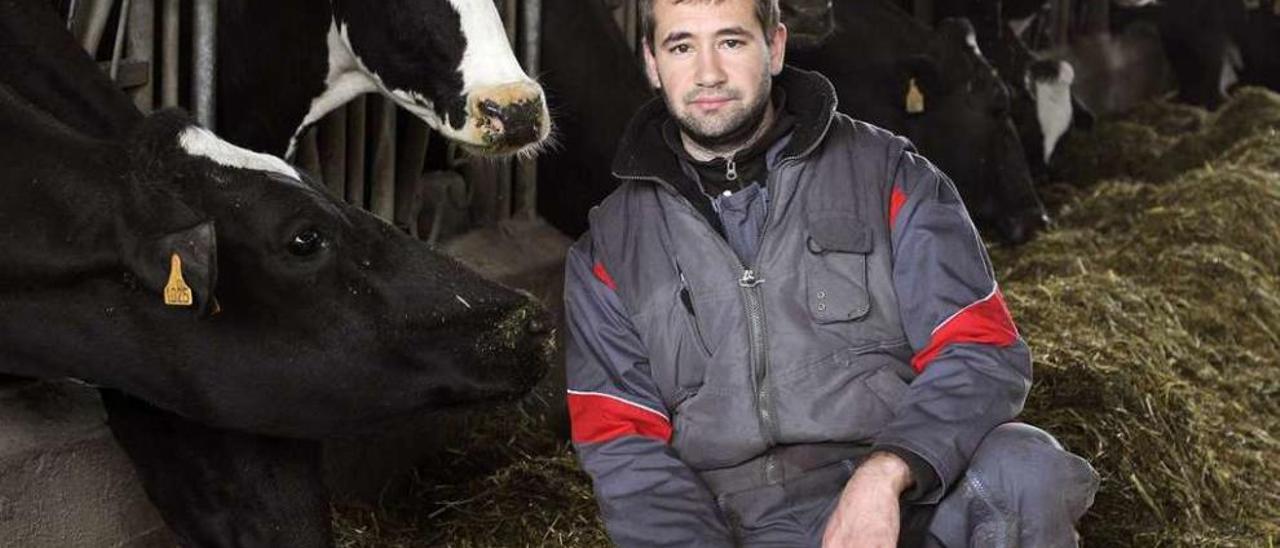 Roman Moulena posa junto a algunas de las vacas de la granja de Santalla. // Bernabé/Javier Lalín