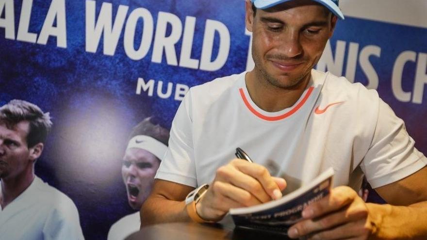 Nadal firma autógrafos en el torneo de exhibición Mubadala World Tennis Championship.