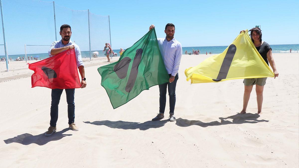 El edil de Playas, el alcalde y la concejala de Turismo, con las banderas.