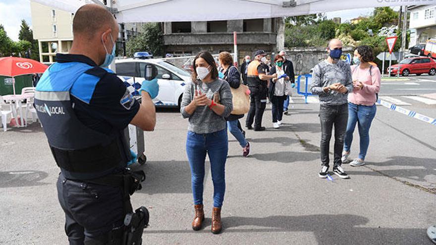 Un policía toma la temperatura a la entrada del feirón.  // L.O.