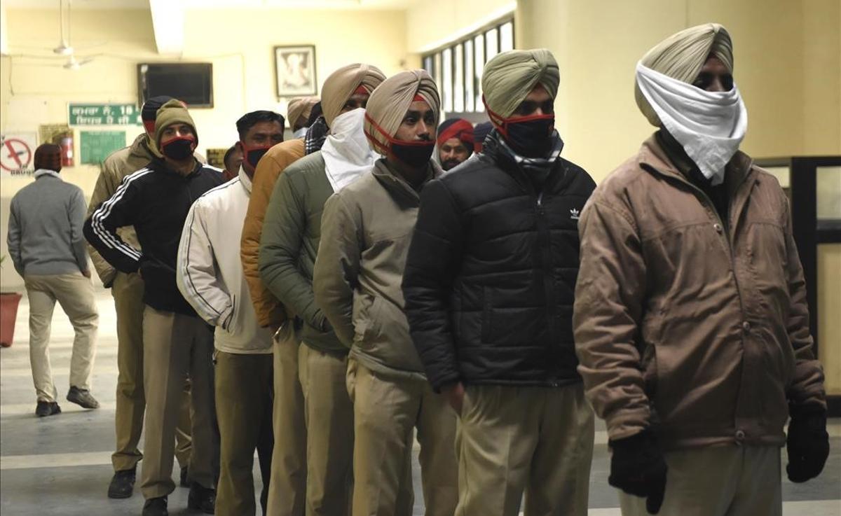 Agentes de la policía del Punjab aguardan en fila para hacerse una prueba de coronavirus en un centro de salud comunitaria a las afueras de Amritsar, India.