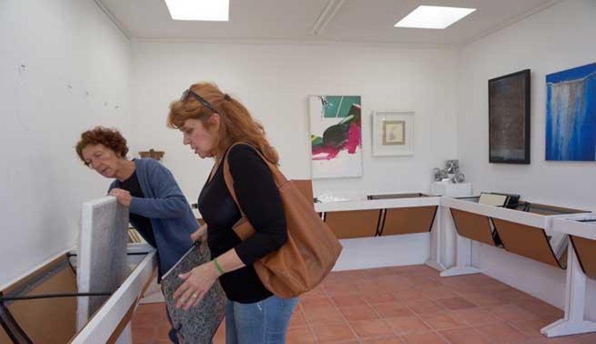 Bernadette Chapu y Maria Catalán desembalan un cuadro de la artista.