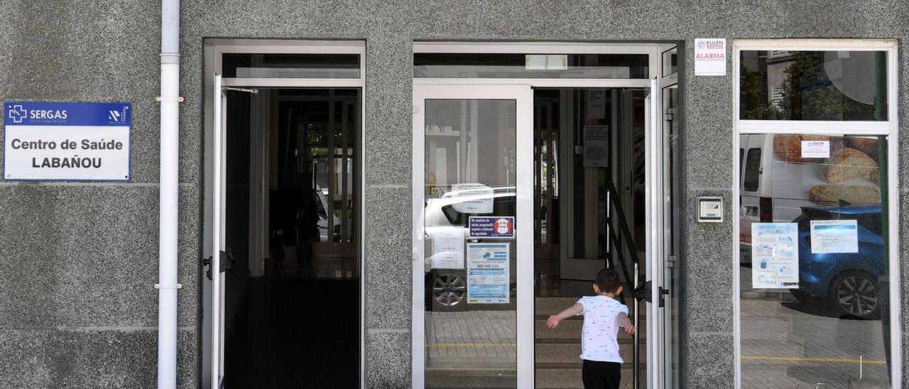 Un niño en la puerta principal del centro de salud del barrio de Labañou. |   // CARLOS PARDELLAS