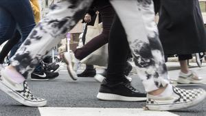 Barcelona     07 12 2020      Sociedad   Aumenta el uso de las zapatillas deportivas como calzado diario  En la foto    desfile de  sneakers   cruzando la calle Aragon   Fotografia de Jordi Cotrina
