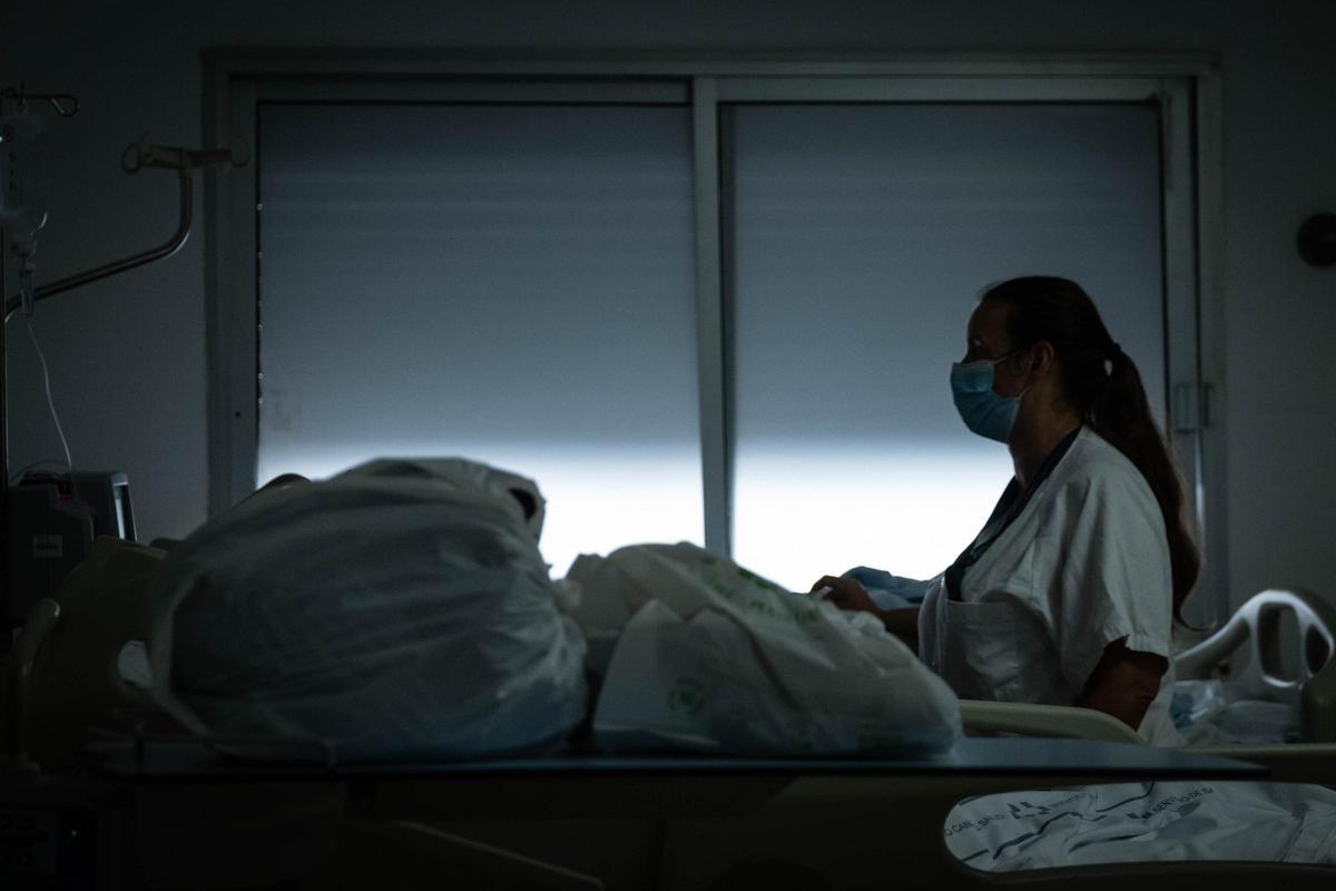 Una sanitaria con un paciente en el Hospital Universitario de Canarias.