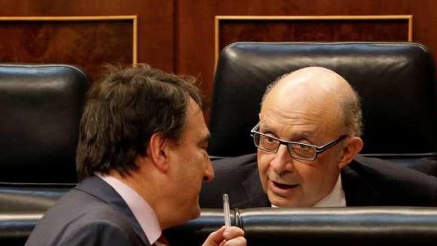 Aitor Esteban, portavoz del PNV, conversa con el ministro de Hacienda, Cristóbal Montoro, durante el debate del Presupuesto.