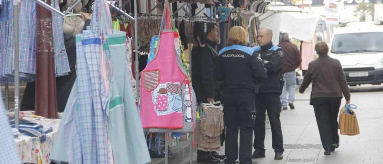 Agentes de la Policía Local charlan con vendedores del mercadillo de Marín. // Santos Álvarez