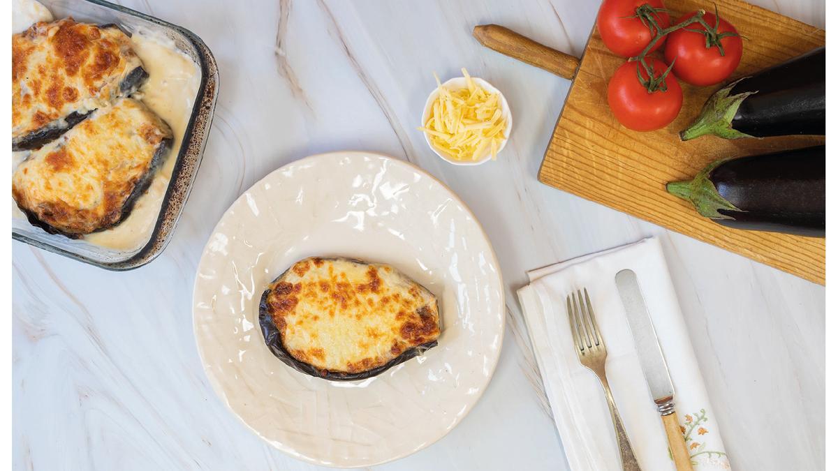 Berenjena rellena de carne picada de cerdo y ternera con sofrito casero de verduras.