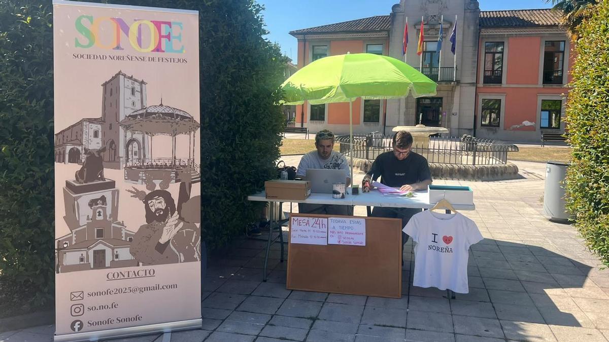 Dos miembros de SONOFE en el puesto instalado en los jardines del Ayuntamiento de Noreña.