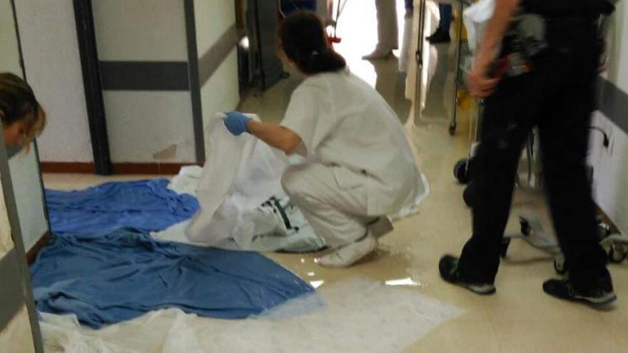 Varias trabajadoras del hospital secan el pasillo que quedó inundado tras la rotura