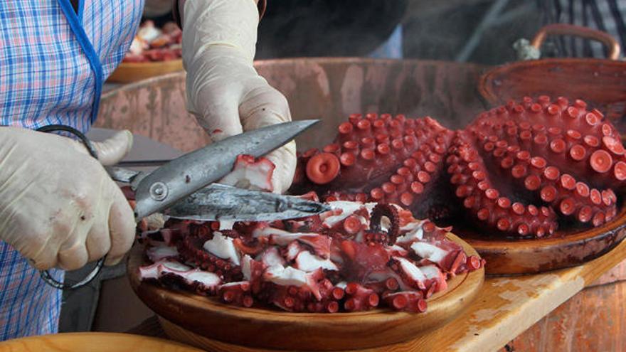 Una pulpera preparando unha ración de su pulpo á feira