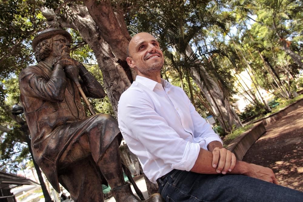 Alfonso Cabello posa junto a la estatua de Enrique González.