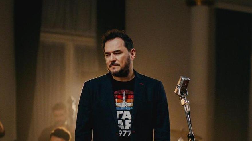 Ismael Serrano acompañado de músicos de orquesta. |