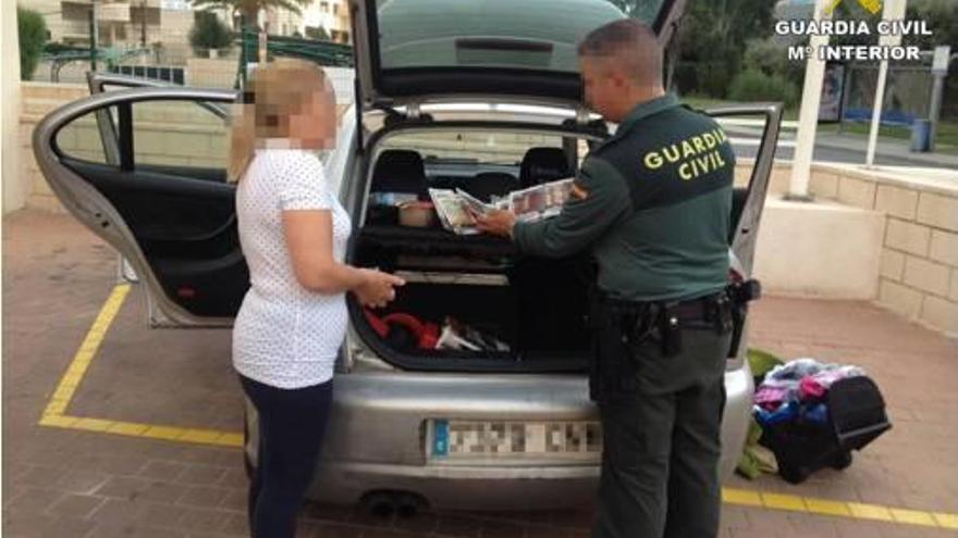 Un agente registra el coche donde llevaban efectos robados.