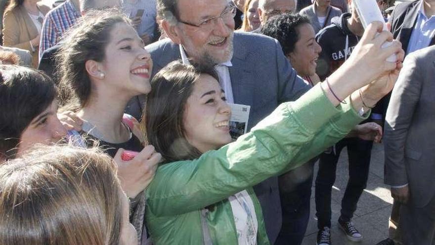 Unas jóvenes se fotografían con Rajoy, ayer en Marín. // S.Álvarez