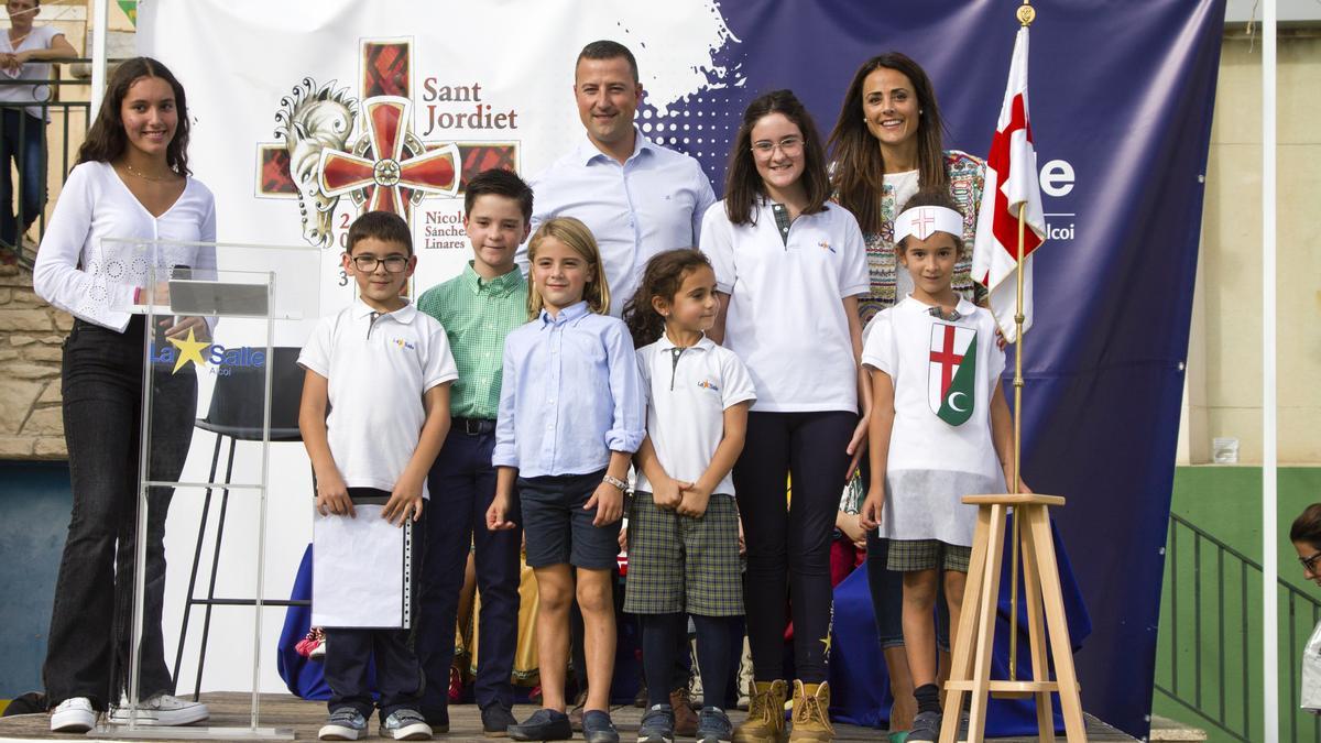 El Sant Jordiet entrante, con sus padres, su predecesor y los premiados en los concursos de poesía y dibujo, además de la presentadora del acto, también alumna de La Salle.