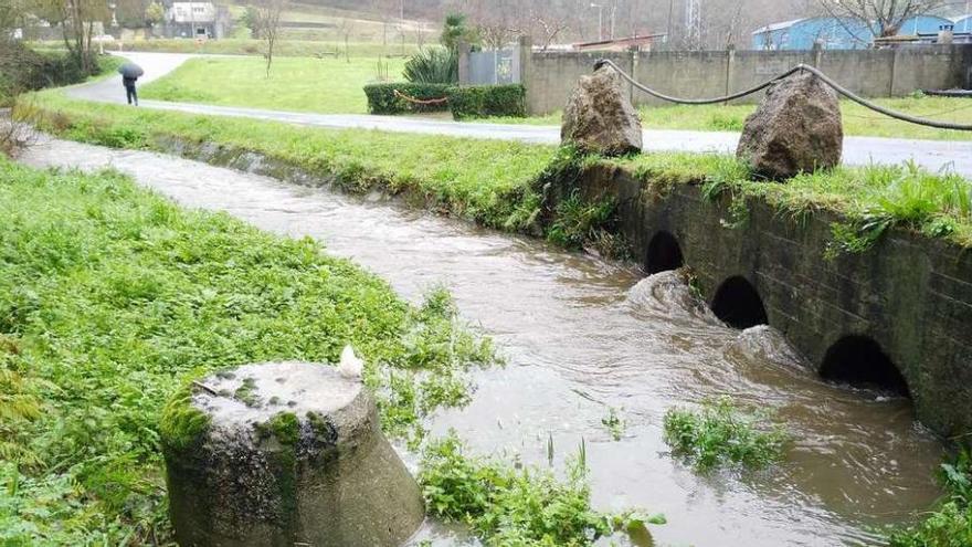 En primer término, arqueta de la que sale el chorro de aguas residuales.