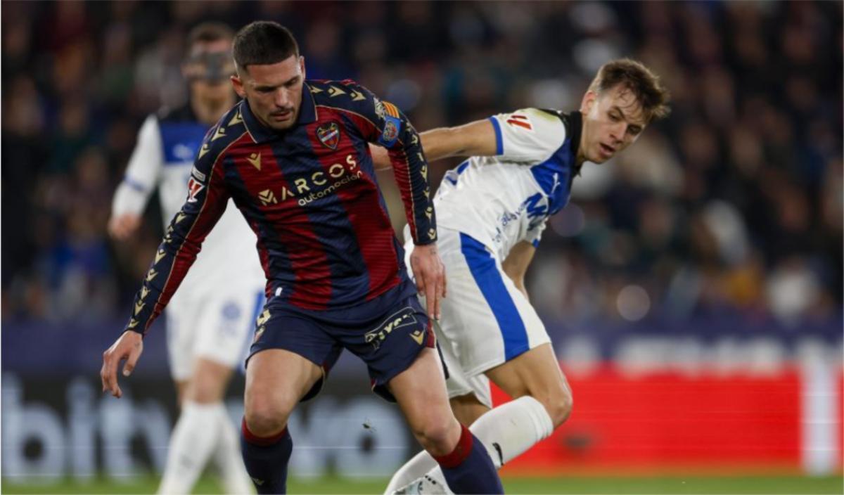 Dela disputando un balón con Pablo Ibáñez