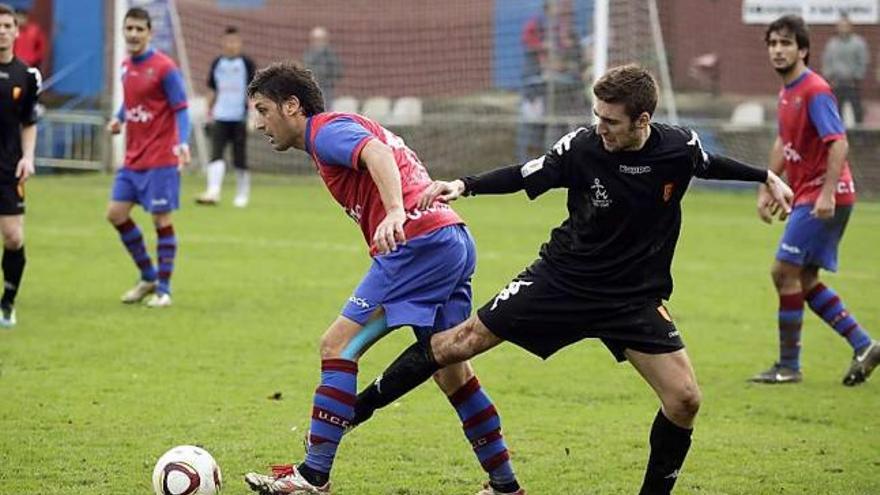 Mario de la Roca protege el balón, ante la presión de Efrén, en un partido en La Cruz.