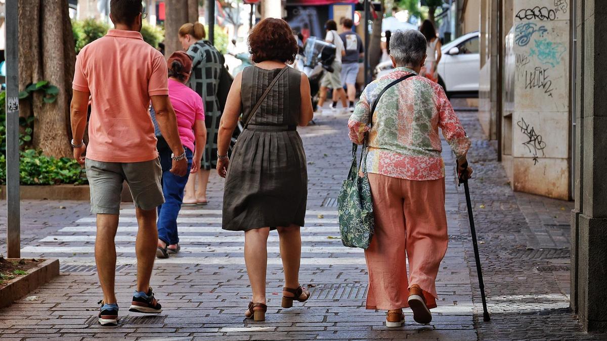 Varios transeúntes, entre ellos personas mayores, en una calle de Santa Cruz de Tenerife.
