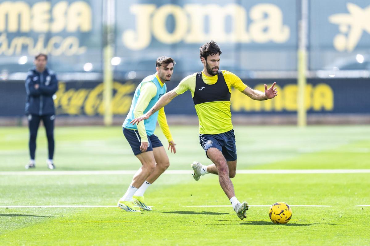 Alfonso Pedraza se dispone a golpear el esférico, ante la mirada de Marcelino García Toral, durante un entrenamiento de la pasada semana.