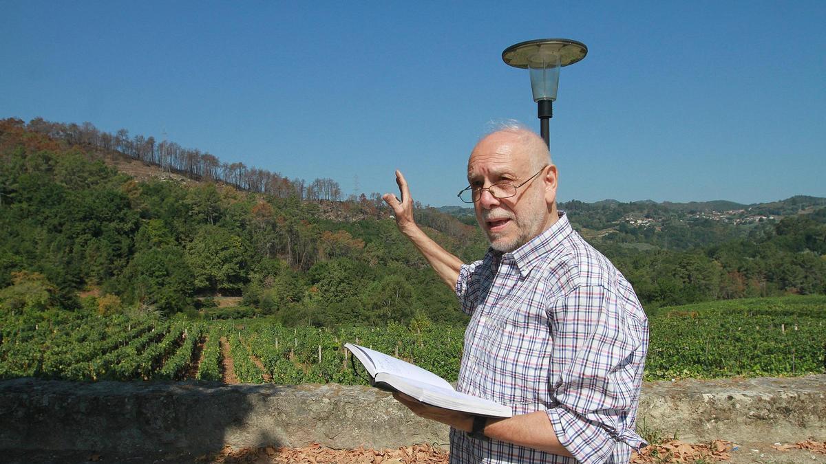 Oitavén, con su cuaderno de apuntes, mostrando desde la iglesia de Beade la cicatriz del fuego en la parte alta de Ridimoas
