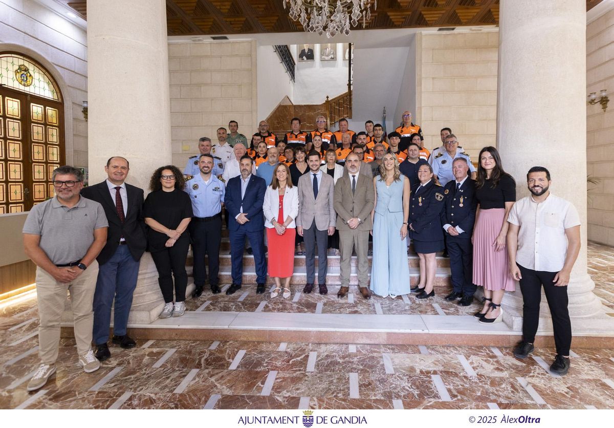 Los voluntarios y voluntarias de Protecció Civil, junto a las autoridades, en la entrada del ayuntamiento