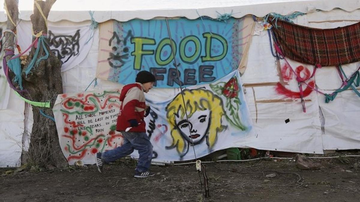 Un niño refugiado corre a la distribución de comida en la localidad de Moria, en la isla griega de Lesbos.