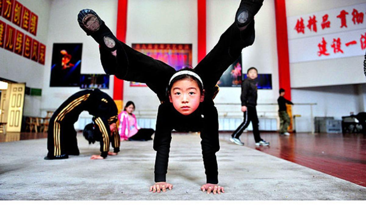 Nenes xineses fan durs exercicis gimnàstics a l¿escola d¿acrobàcies de Shenyang, a la província de Liaoning, on s¿hauran de formar entre 6 i 10 anys.