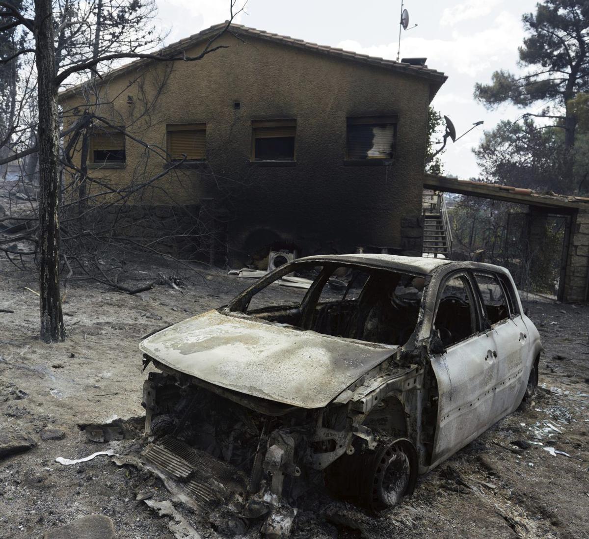 L’UME i els bombers de Castella i Lleó combaten el foc al costat de la urbanització La Atalaya, a El Tiemblo, a 80 quilòmetres de Madrid. |  CÉSAR MANSO / AFP)