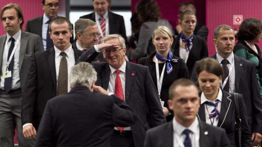 Jean-Claude Juncker saluda a Jean-Claude Trichet (de espaldas) ayer en el Ecofin.