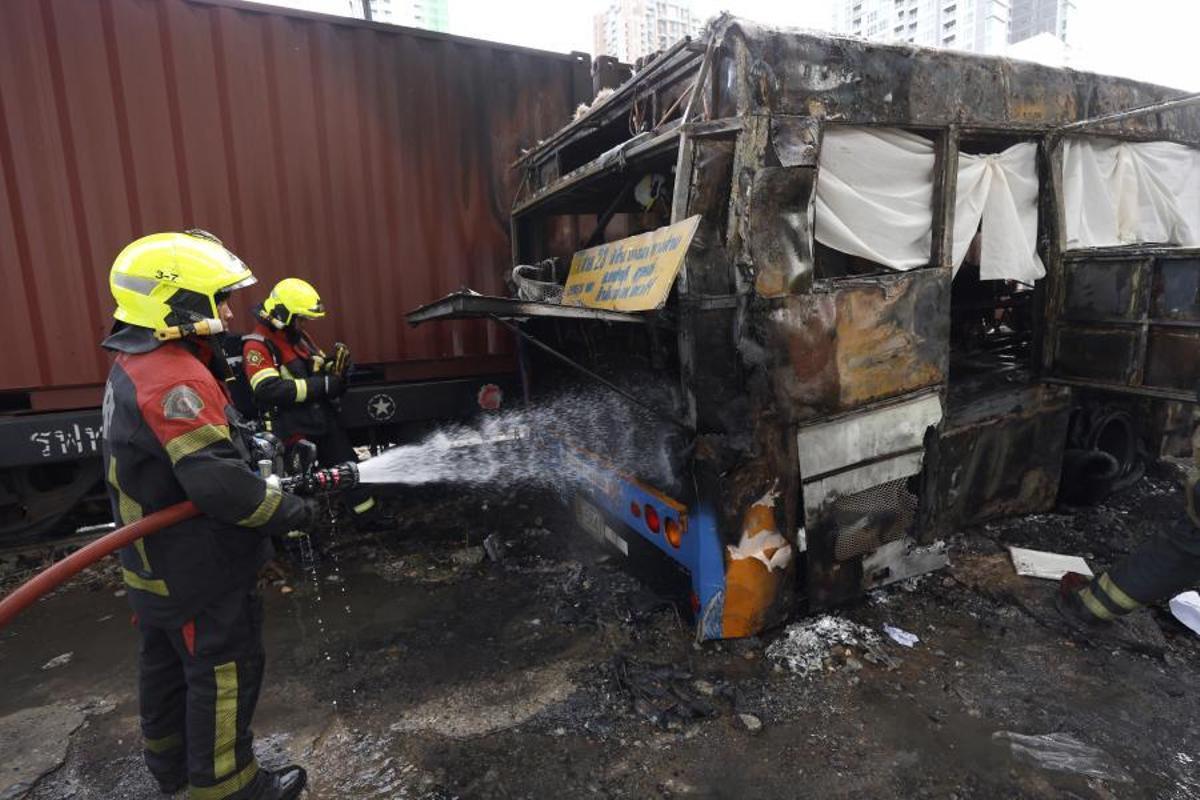 Imágenes del accidente entre un tren y un autobús en Bangkok, que ha dejado al menos ocho muertos y 25 heridos después de que el vehículo se incendiara tras el impacto.
