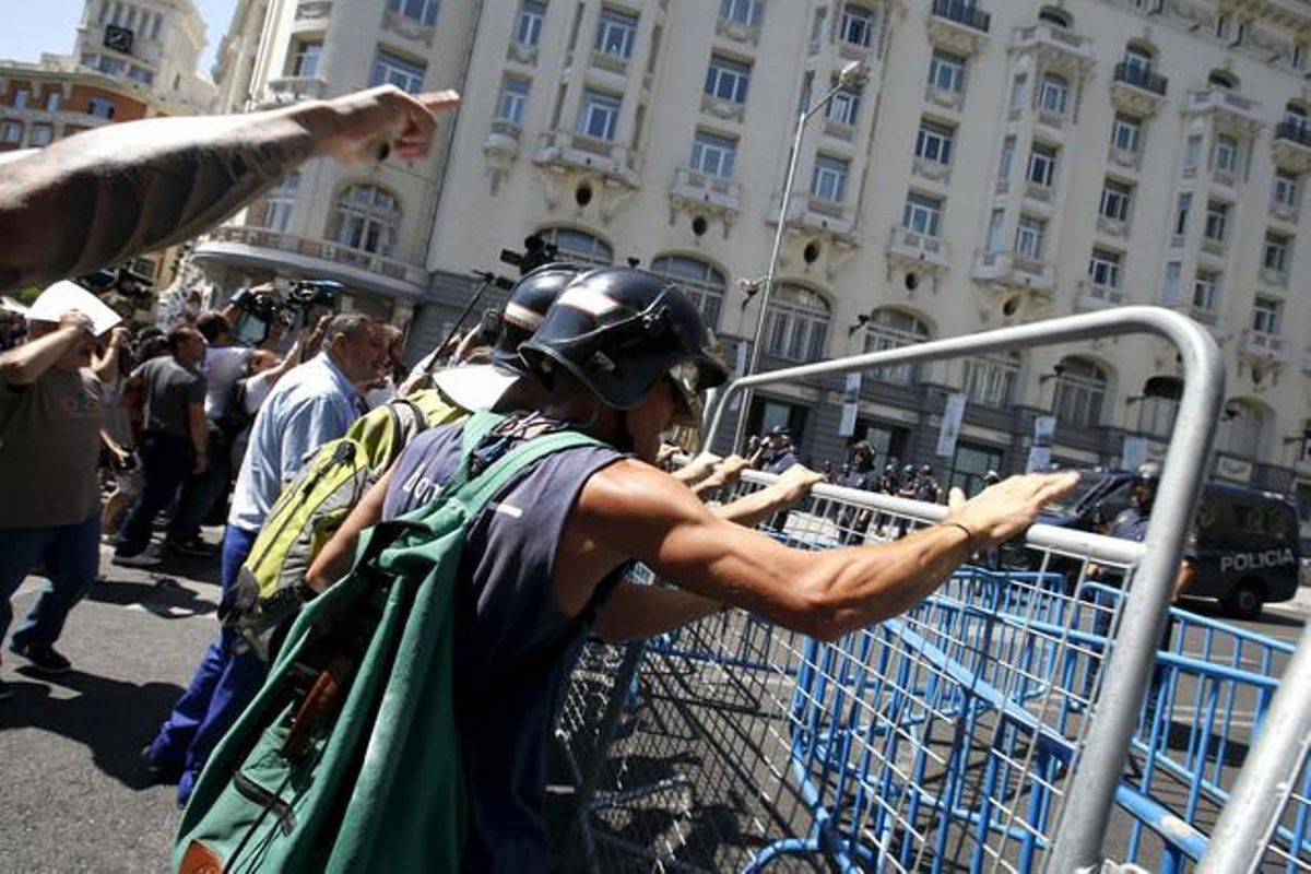 Diversos bombers intenten tirar a terra les tanques col·locades a la plaça de Neptuno per la policia per impedir el pas de la manifestació dels funcionaris.