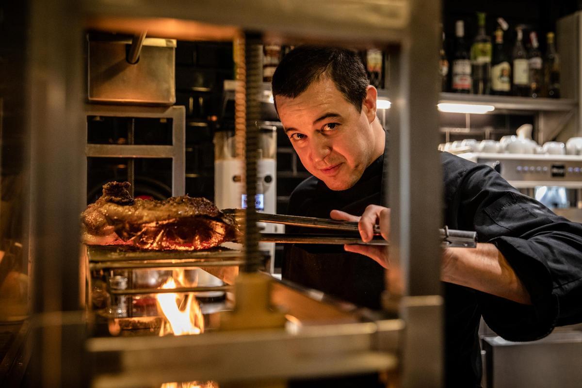El chef Jordi Bernús, junto a la parrilla en su restaurante 'Sants es crema'