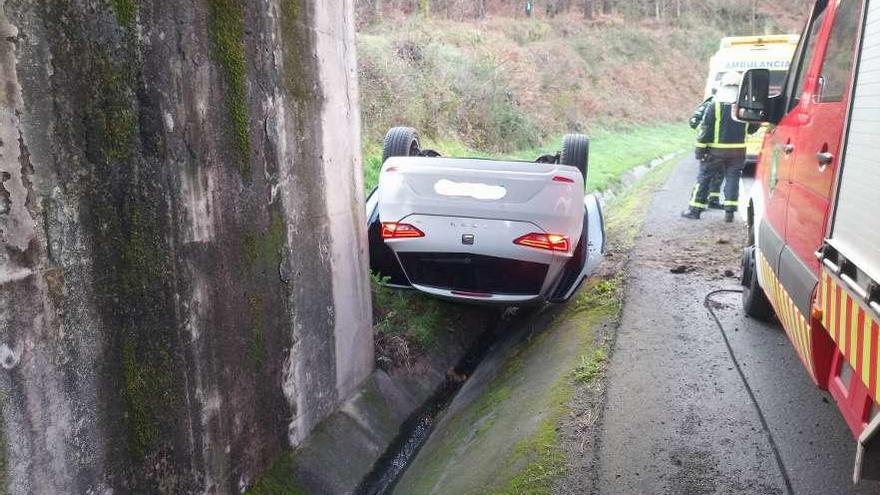 El coche volcado ayer a la altura de Cordeiro (Valga). // FdV