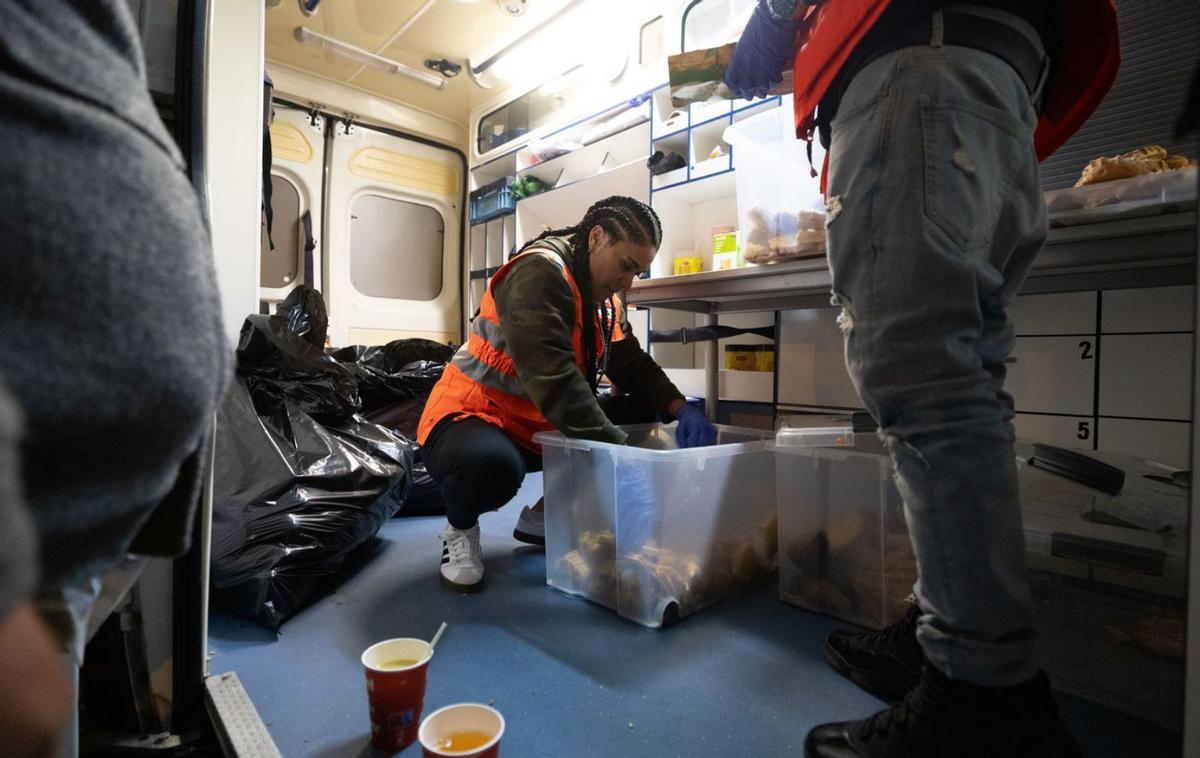 Una voluntaria de Cruz Roja prepara una de las bolsas de alimentos dentro del furgón. | VICENT MARÍ