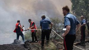 Bomberos intentan apagar los incendios que rodean la ciudad de Palermo, en Sicilia.