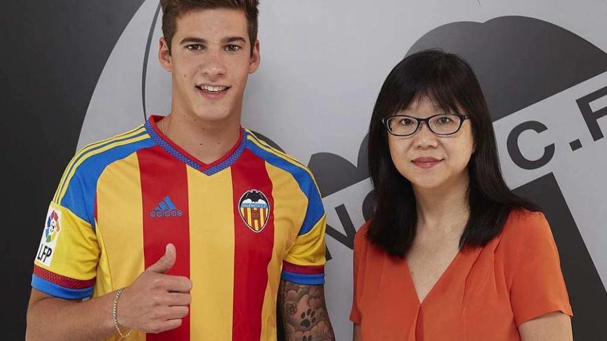 Santi Mina posa con la segunda equipación del Valencia, junto a Lay Hoon Chan, presidenta del club valenciano.