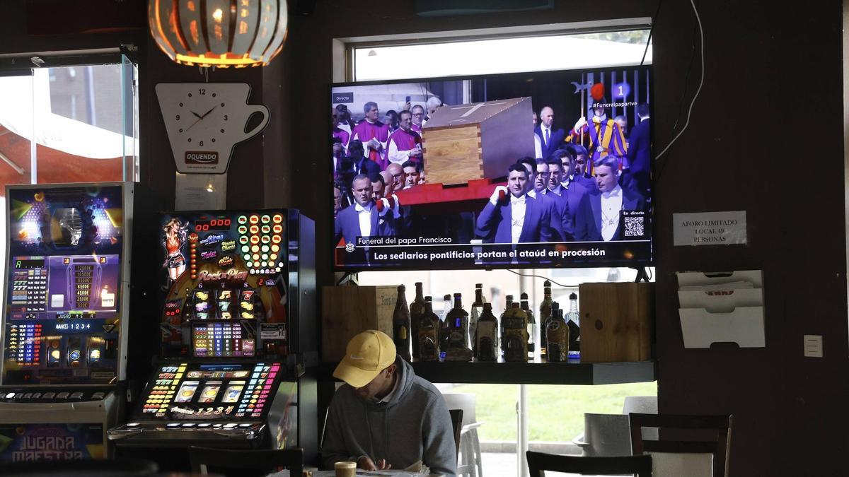 Un cliente del "Ruben's" lee LA NUEVA ESPAÑA durante el traslado del Papa.