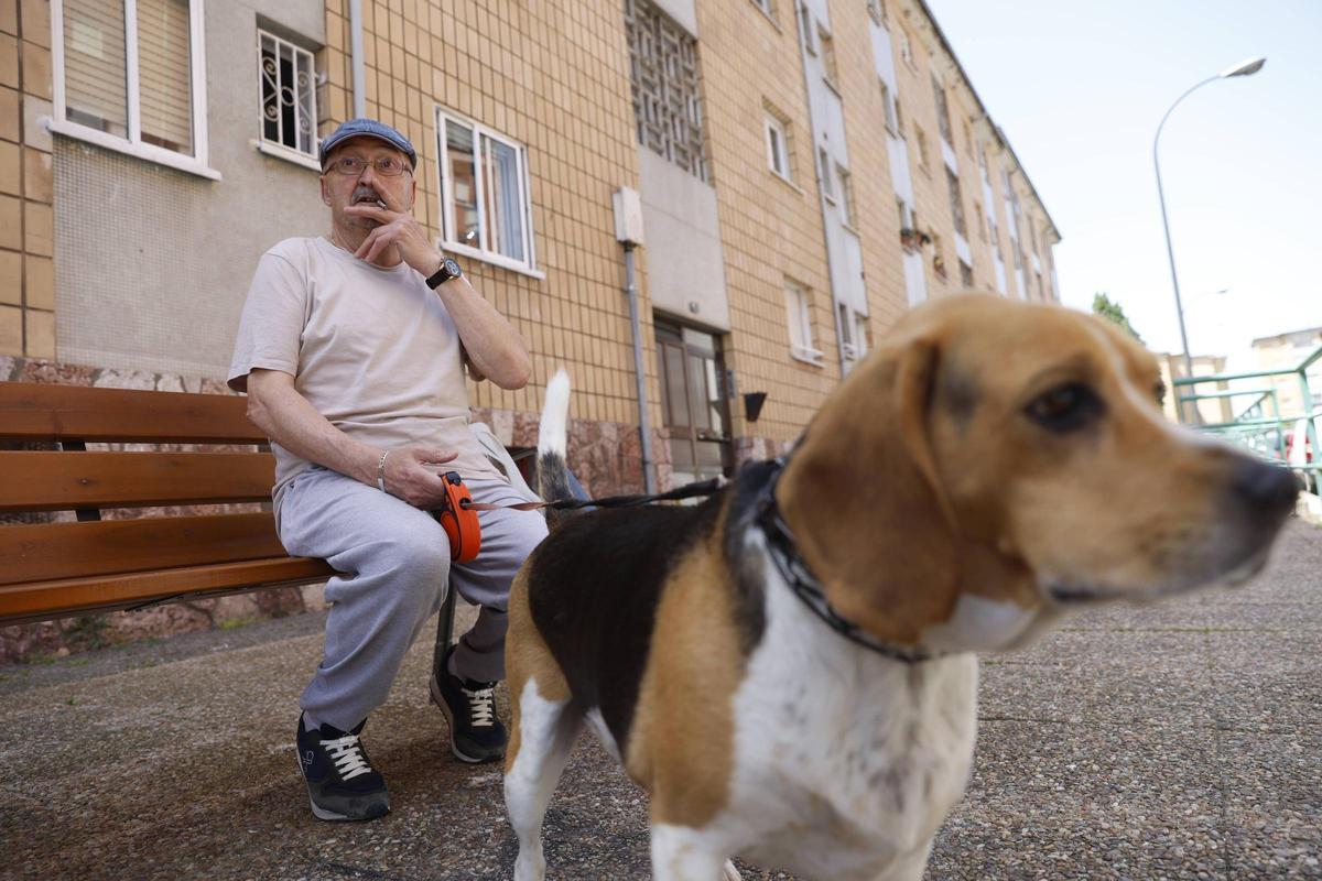 Ramón Pérez descansa en un banco con su perro.