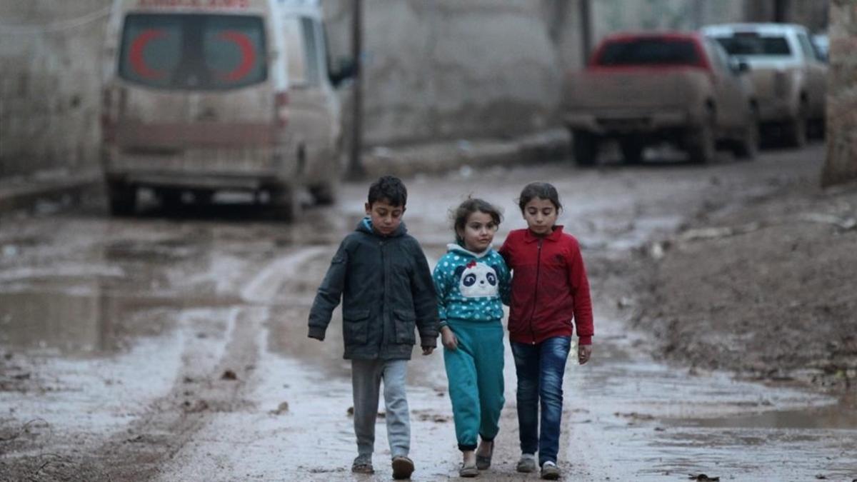 Niños caminan cerca de una ambulancia aparcada en Al-Rai, en la provincia de Alepo, en Siria, el 27 de diciembre.